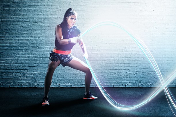 Glasfaser von envia TEL Eine Frau beim Rope Training, wobei die Seile durch leuchtende digitale Stränge dargestellt sind