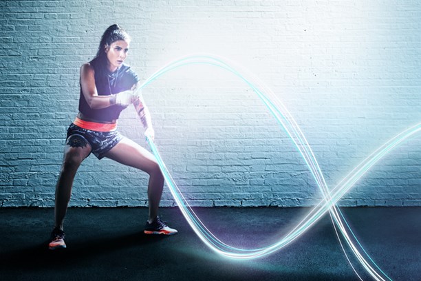 Glasfaser von envia TEL Eine Frau beim Rope Training, wobei die Seile durch leuchtende digitale Stränge dargestellt sind