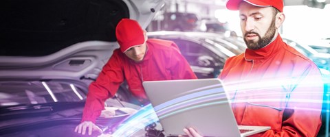 Glasfaserverbindung in Werkstatt & Autohaus enviaTEL KFZ-Mechatroniker arbeitet mit Laptop und envia-TEL-Glasfaserverbindung