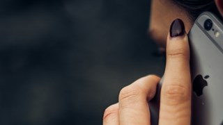 Telefonie Frau hält sich ein Telefon an ihr Ohr