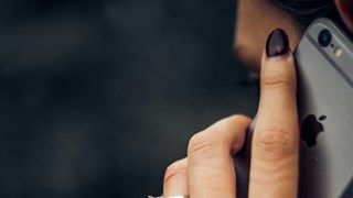 Telefonie Frau hält sich ein Telefon an ihr Ohr