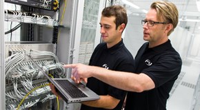 enManaged-Datacenter-Servicekatalog enviaTEL Zwei Mitarbeiter der envia TEL mit einem Laptop in der Hand, im Datacenter vor Blades