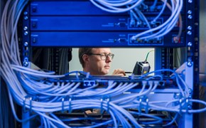 envia-TEL_DE-CIX-Leipzig_Datacenter-Experte Großes Rack im Datacenter Leipzig, eine Blade entnommen, durch die Lücke ist Datacenter-Experte der envia TEL zu sehen