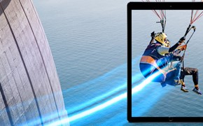 Next Generation Firewalls Zwei Personen fliegen mit einem Gleitschirm vor einer Staumauer