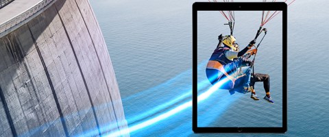 Next Generation Firewalls Zwei Personen fliegen mit einem Gleitschirm vor einer Staumauer