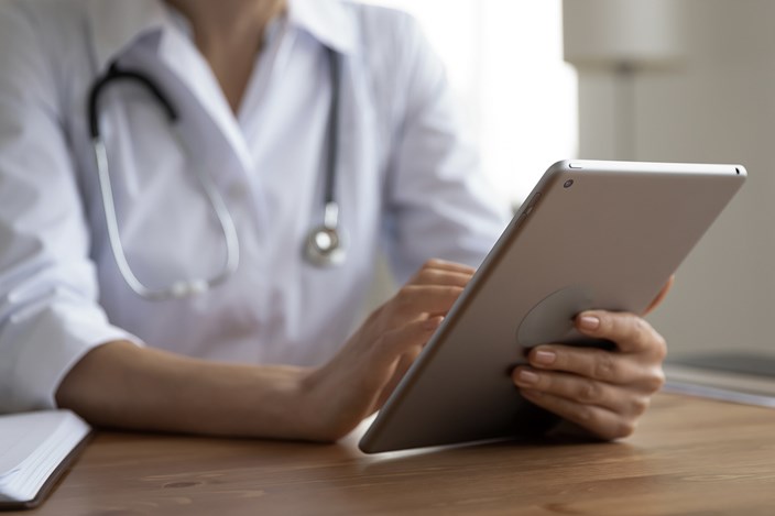 Digitale Transformation in Arztpraxen enviaTEL Arzt mit Tablet in der Hand