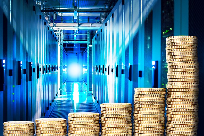 Auswirkungen der Strompreise auf Rechenzentren Gestapelte Münzen vor beleuchtetem Serverraum-Gang