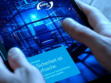 Whitepaper Cyber-Sicherheit ist Chefsache Mann hält ein Tablet in der Hand, das Tablet zeigt das Cover des Whitepapers Cyber-Sicherheit ist Chefsache mit dem envia TEL Logo