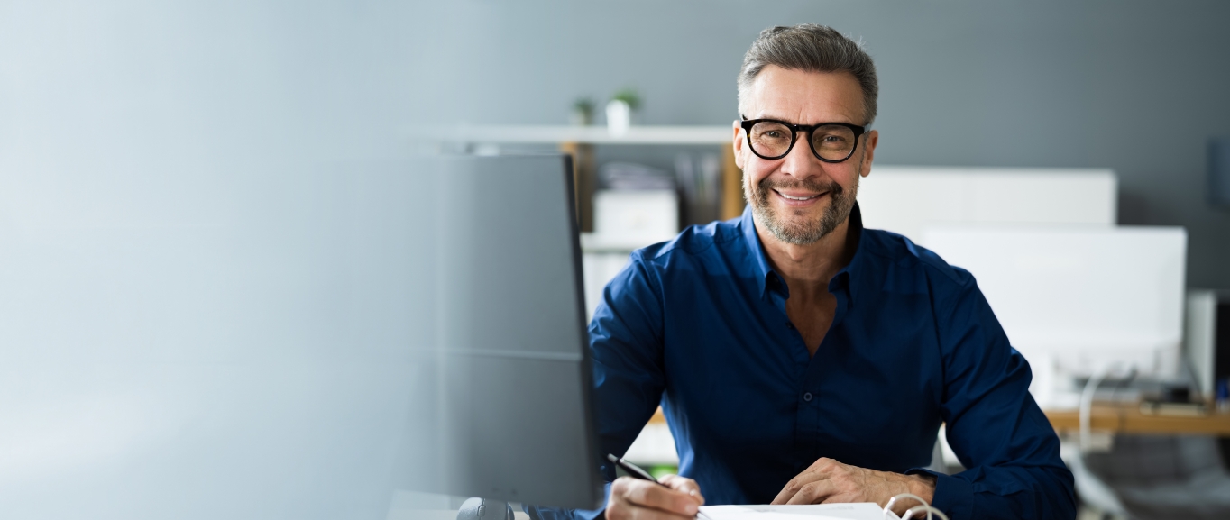 Mann im Büro lächelt in die Kamera