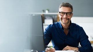 Security-Newsletter enviaTEL Mann im Büro lächelt in die Kamera