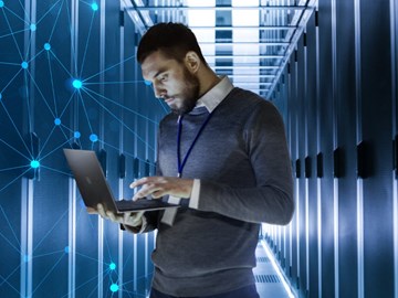 IT-Spezialist-enGiga-Secure-Netbased-Firewall IT-Spezialist mit Computer in der Hand, sorgt im Datacenter für Sicherheit