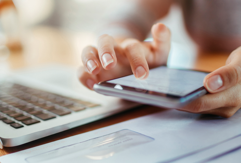 Nahaufnahme einer weiblichen Hand, die ein Handy bedient