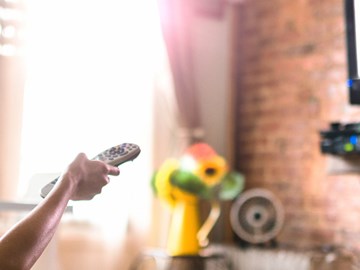 IPTV für Reseller Header Frau sitzt im Sessel und schaut Fernsehen