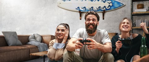 Highspeed-Internet für zu Hause Drei junge Menschen spielen zu Hause begeistert ein Videospiel
