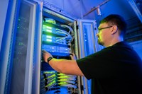 Werkstudentenjob bei der envia TEL Auszubildender bei der Arbeit vor einem Serverschrank