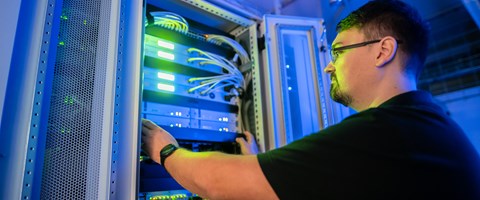 Werkstudentenjob bei der envia TEL Auszubildender bei der Arbeit vor einem Serverschrank