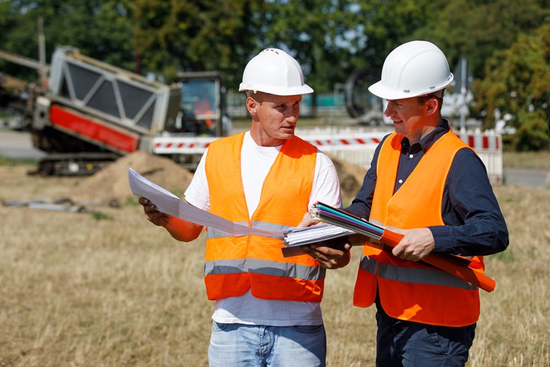 Glasfaser Ausbau Zwei Männer mit Ausbauplan und Glasfaserleerrohren in der Hand