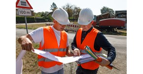 Glasfaser Ausbau Zwei Männer mit Ausbauplan und Glasfaserleerrohren in der Hand