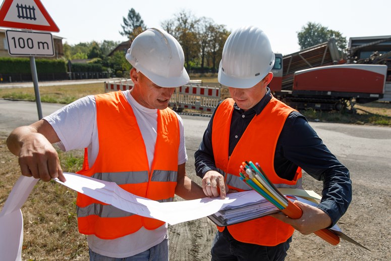 Glasfaser Ausbau Zwei Männer mit Ausbauplan und Glasfaserleerrohren in der Hand