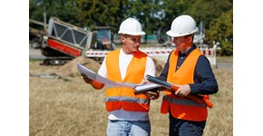 Glasfaser Ausbau Zwei Männer mit Ausbauplan und Glasfaserleerrohren in der Hand