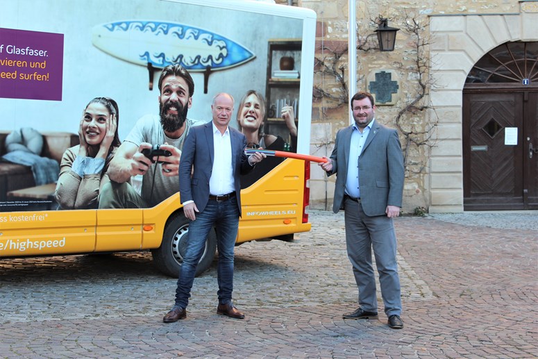 envia TEL Glasfaser für Querfurt Haiko Rennert, Geschäftsführer der envia TEL, und Andreas Nette, Bürgermeister der Stadt Querfurt, vor dem envia TEL Bus mit symbolischen Glasfaserkabeln in den Händen