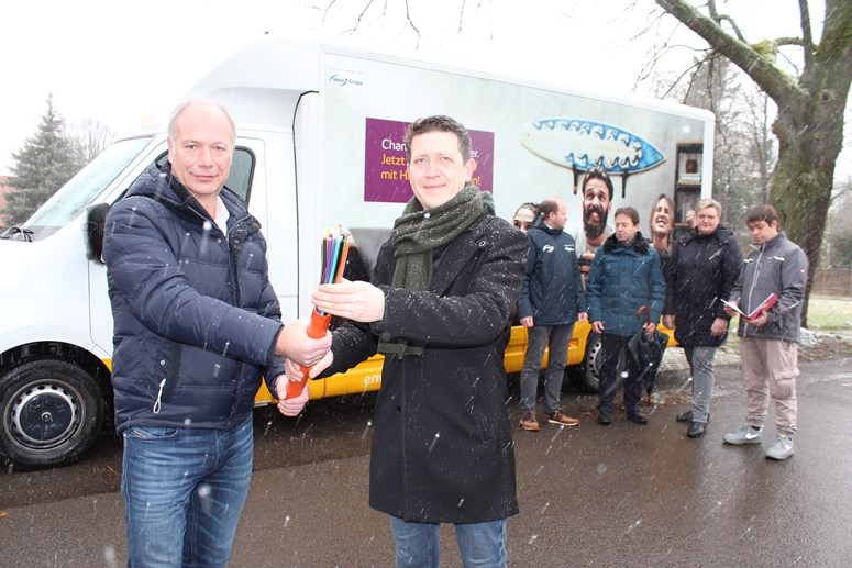 Foto erfolgreiche VVM Güldengossa Haiko Rennert, Geschäftsführer der envia TEL, mit dem Bürgermeister der Stadt Güldengossa vor dem envia TEL Bus und symbolischen Glasfaserkabeln in der Hand