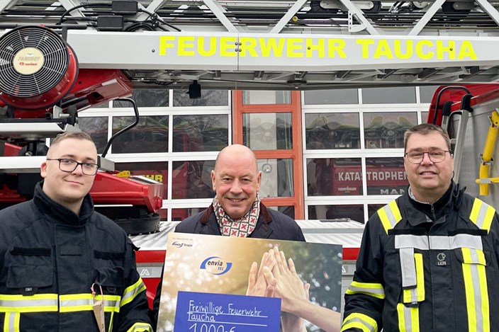 Jugendfeuerwehr Taucha mit Stephan Drescher der envia TEL Stephan Drescher, Geschäftsführer der envia TEL, steht mit Feuerwehrmännern vor der Feuerwache in Taucha und hält einen Scheck in der Hand